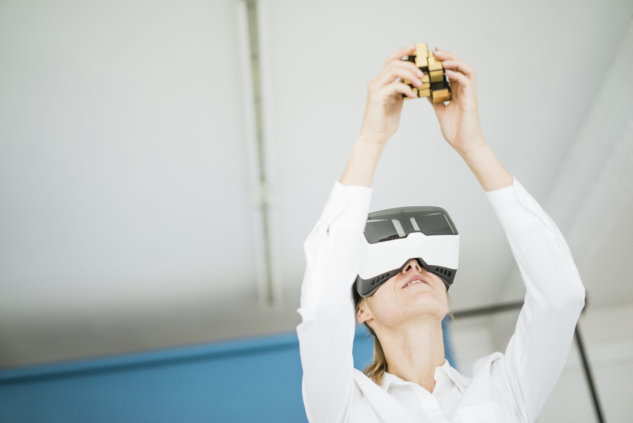 Businesswoman wearing VR glasses holding cubical structure